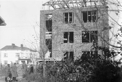 Fotografia z rodzinnego archiwum ukazująca budowę trzeciego z kolei domu Januszy, tj. modernistycznej kamienicy przy ul. Poniatowskiego 10. Zwraca uwagę, że nowy dom został wybudowany w granicy posesji należącej do willi Fryderyka, kt&oacute;rą widzimy w tle. Zdjęcie ze zbior&oacute;w Galerii Fotografii Miasta Rzeszowa